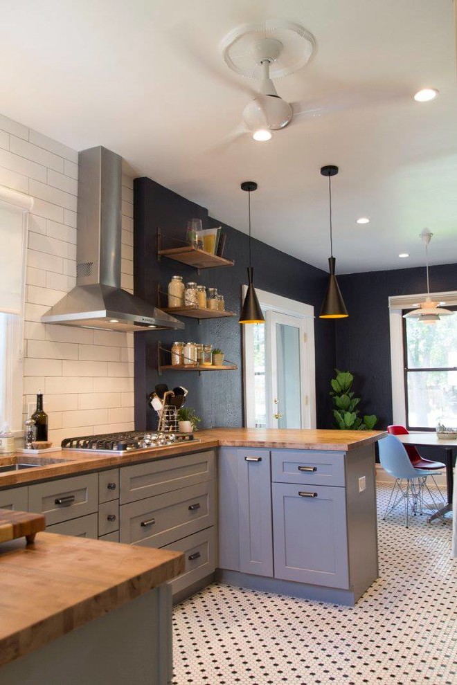 Photo of a mid-sized midcentury galley eat-in kitchen in Denver with an undermount sink, shaker cabinets, grey cabinets, wood benchtops, white splashback, ceramic splashback, stainless steel appliances, ceramic floors, a peninsula and white floor.