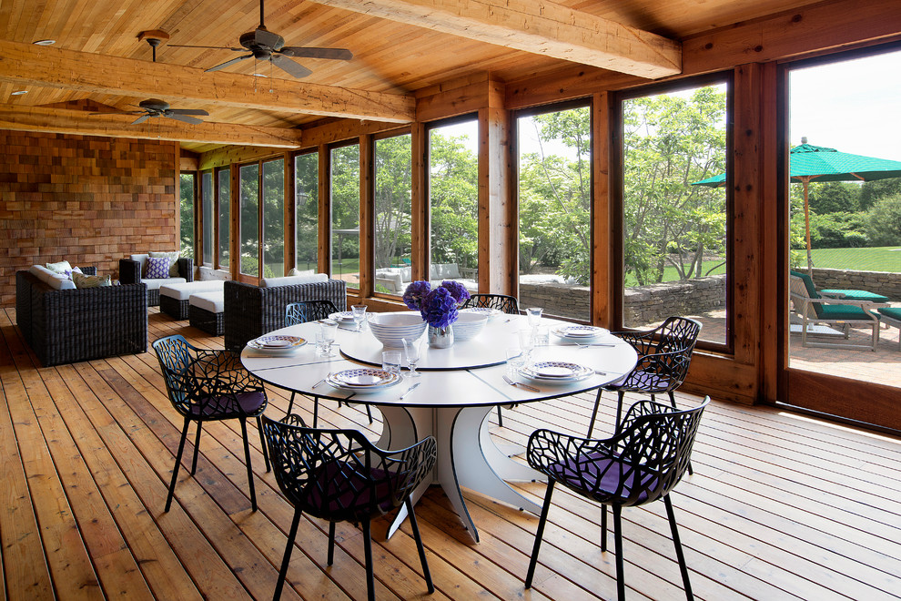 Inspiration for a large rustic backyard deck remodel in New York with a roof extension