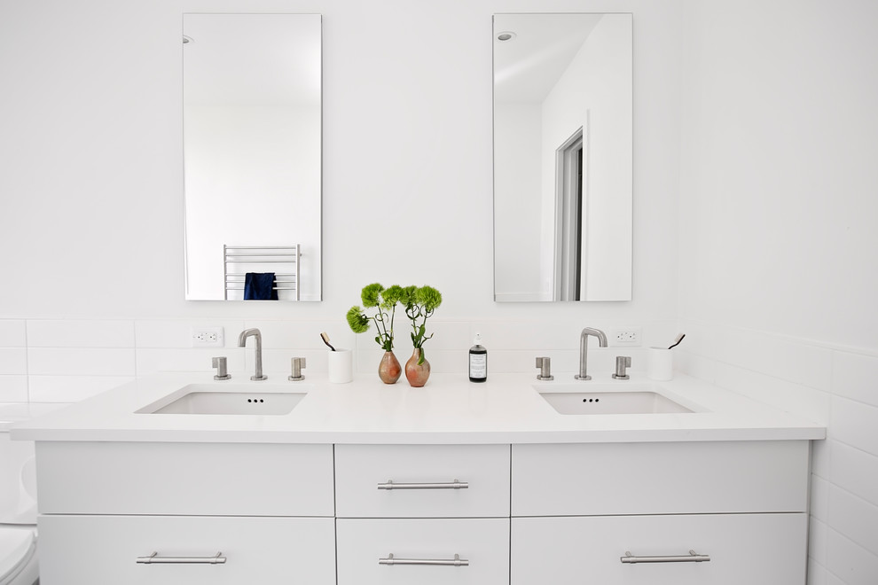 This is an example of a mid-sized modern master bathroom in New York with white cabinets, an open shower, a one-piece toilet, blue tile, porcelain tile, white walls, porcelain floors, an undermount sink, concrete benchtops, blue floor, an open shower, white benchtops and flat-panel cabinets.