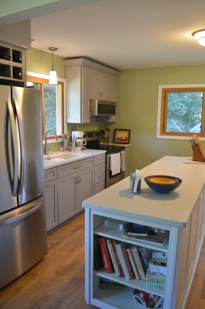 Example of a small transitional single-wall vinyl floor eat-in kitchen design with an undermount sink, shaker cabinets, gray cabinets, solid surface countertops, stainless steel appliances, an island and white countertops