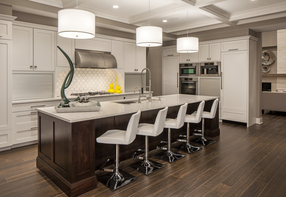 Inspiration for a large transitional l-shaped kitchen in Omaha with an undermount sink, shaker cabinets, white cabinets, quartz benchtops, white splashback, stainless steel appliances, dark hardwood floors and with island.