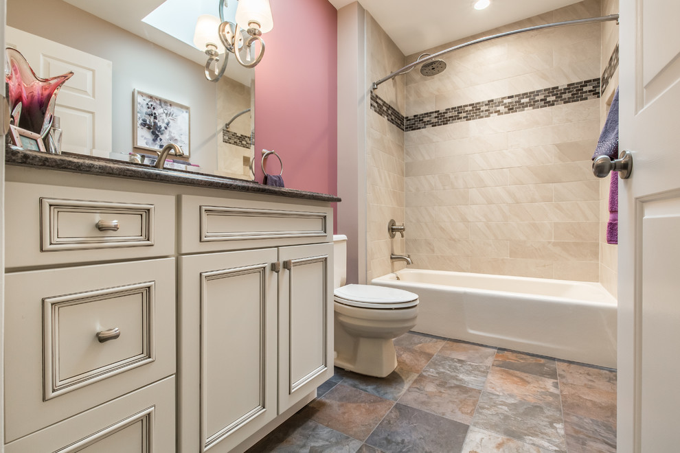 This is an example of a mid-sized transitional kids bathroom in DC Metro with flat-panel cabinets, white cabinets, an alcove tub, an alcove shower, a two-piece toilet, beige tile, porcelain tile, pink walls, porcelain floors, an undermount sink, granite benchtops, multi-coloured floor and a shower curtain.