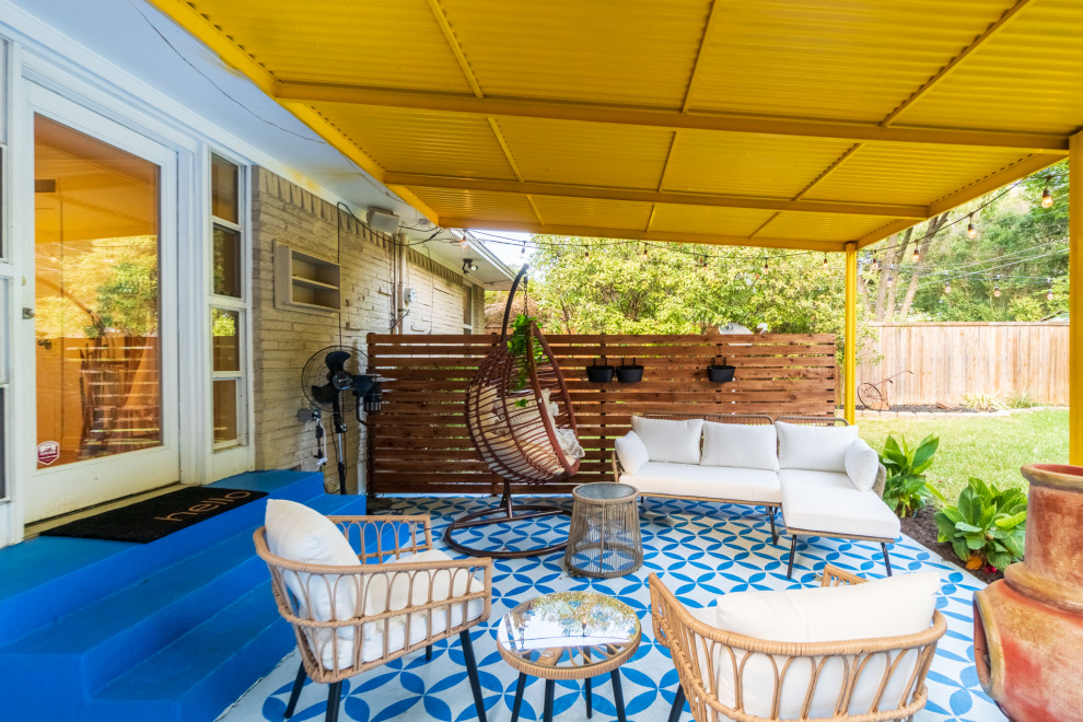 Design ideas for a mid-sized eclectic backyard patio in Dallas with a fire feature, concrete slab and an awning.