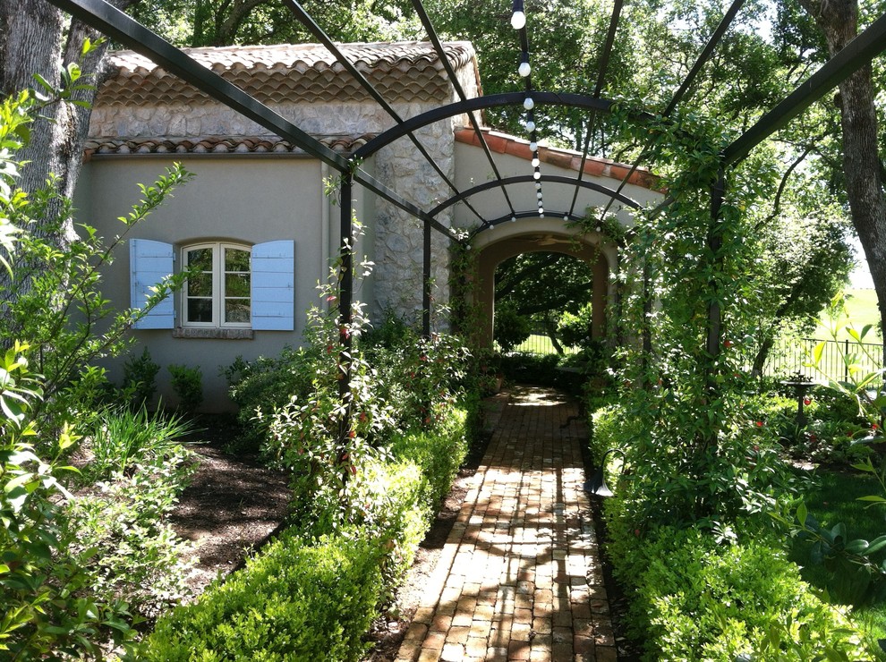 Design ideas for a country backyard shaded garden in Sacramento with brick pavers.