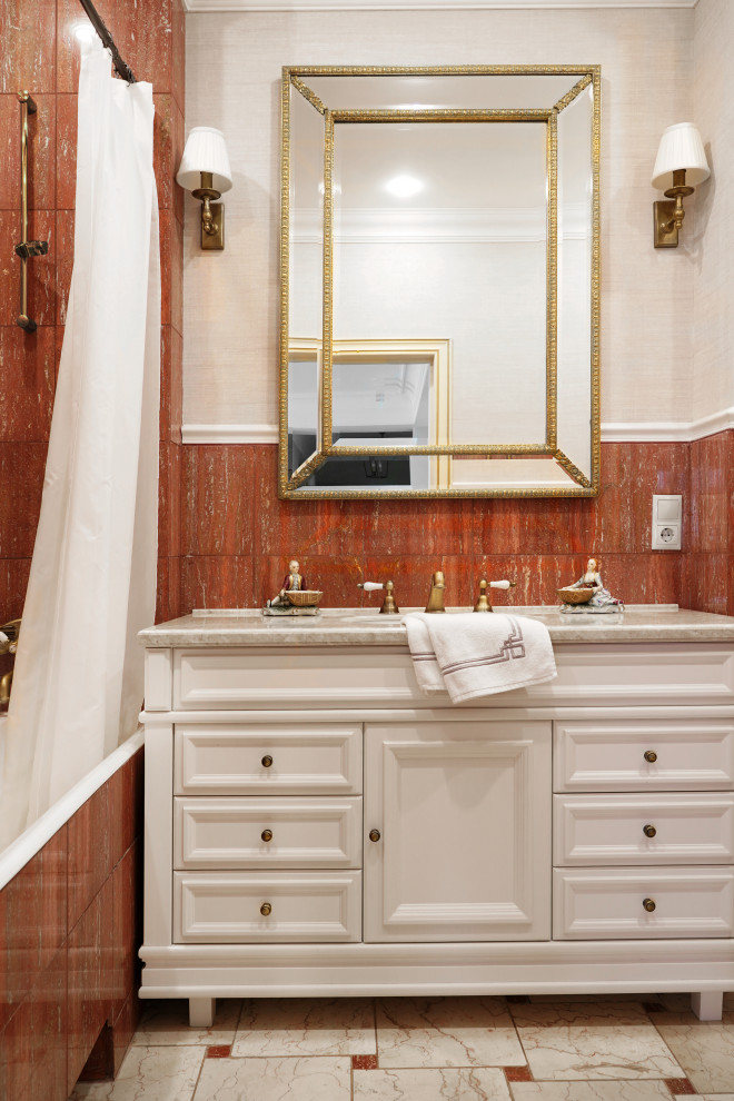 Cette image montre une petite salle de bain principale traditionnelle avec un placard avec porte à panneau surélevé, des portes de placard blanches, une baignoire en alcôve, un combiné douche/baignoire, WC à poser, un carrelage rouge, du carrelage en marbre, un mur beige, un sol en marbre, un lavabo encastré, un plan de toilette en surface solide, un sol beige, une cabine de douche avec un rideau, un plan de toilette beige, une niche, meuble simple vasque, meuble-lavabo sur pied et du papier peint.