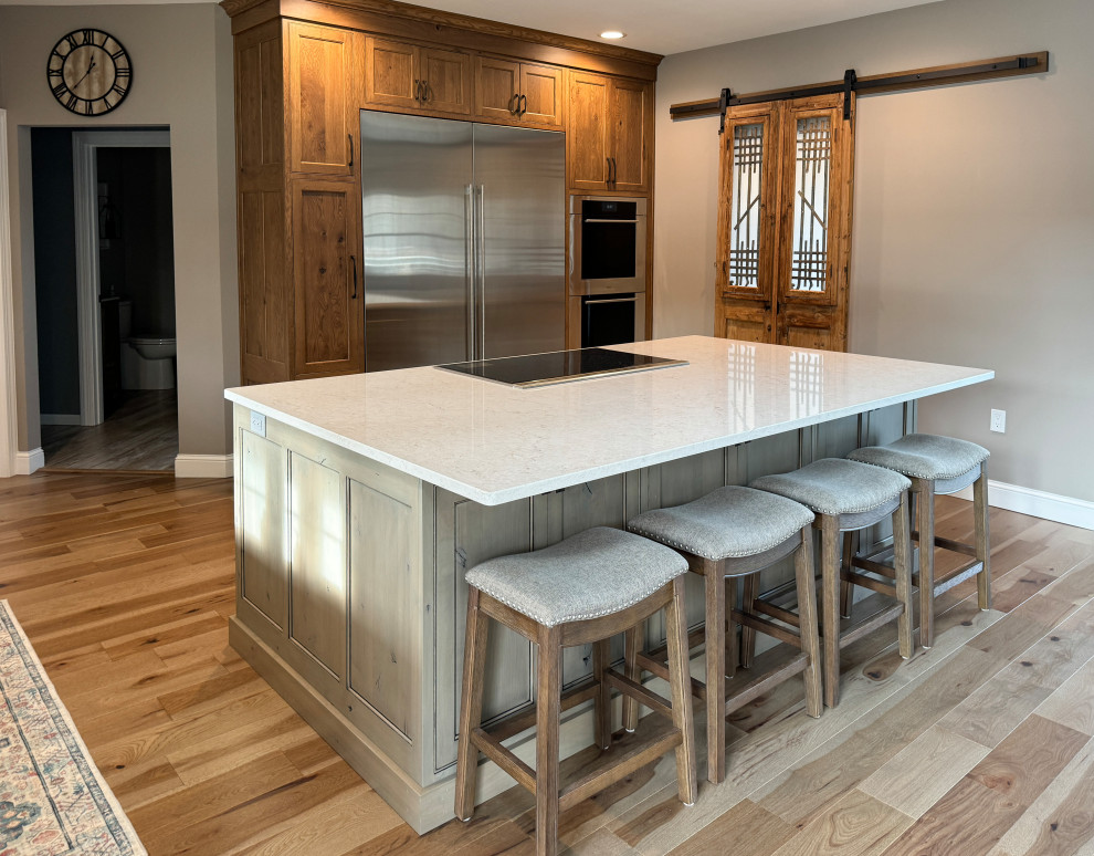 Inspiration for a large transitional l-shaped light wood floor eat-in kitchen remodel with beaded inset cabinets, quartz countertops, stainless steel appliances and an island
