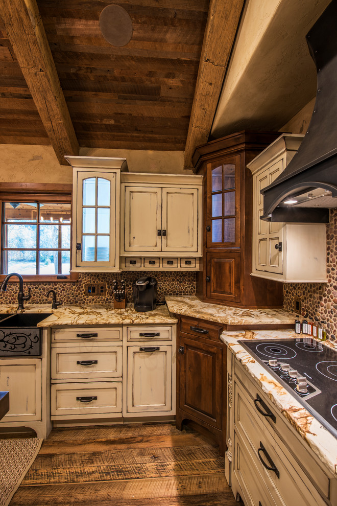 Photo of a large country u-shaped separate kitchen in Other with a farmhouse sink, recessed-panel cabinets, distressed cabinets, granite benchtops, panelled appliances, with island, brown splashback and dark hardwood floors.
