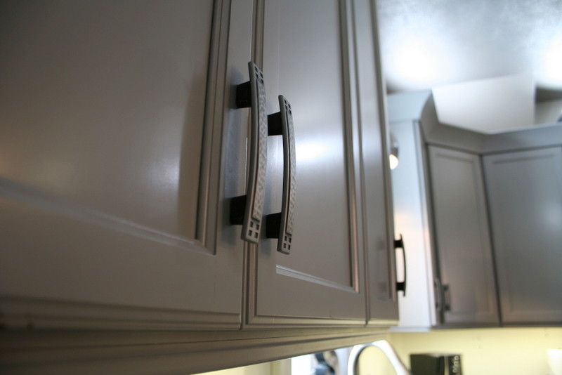 Example of a small transitional l-shaped vinyl floor enclosed kitchen design with a double-bowl sink, flat-panel cabinets, gray cabinets, quartz countertops, stainless steel appliances and an island