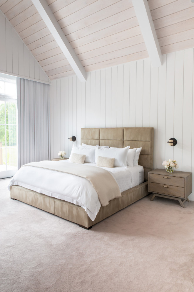Aménagement d'une grande chambre classique avec un mur blanc, une cheminée, un manteau de cheminée en lambris de bois, un sol beige, un plafond voûté et du lambris.