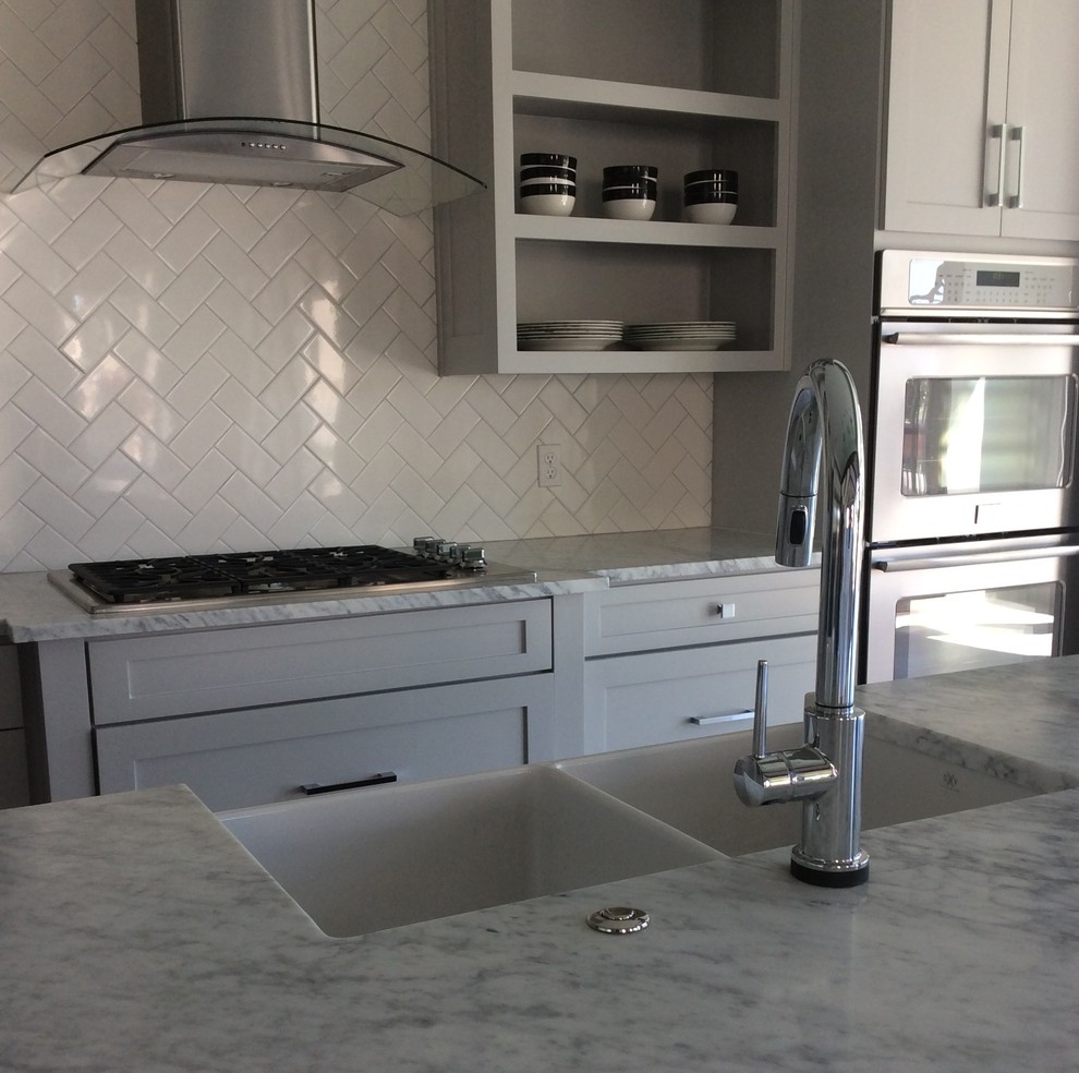Design ideas for a large modern u-shaped separate kitchen in Other with a farmhouse sink, recessed-panel cabinets, grey cabinets, quartzite benchtops, white splashback, subway tile splashback, stainless steel appliances, with island and travertine floors.