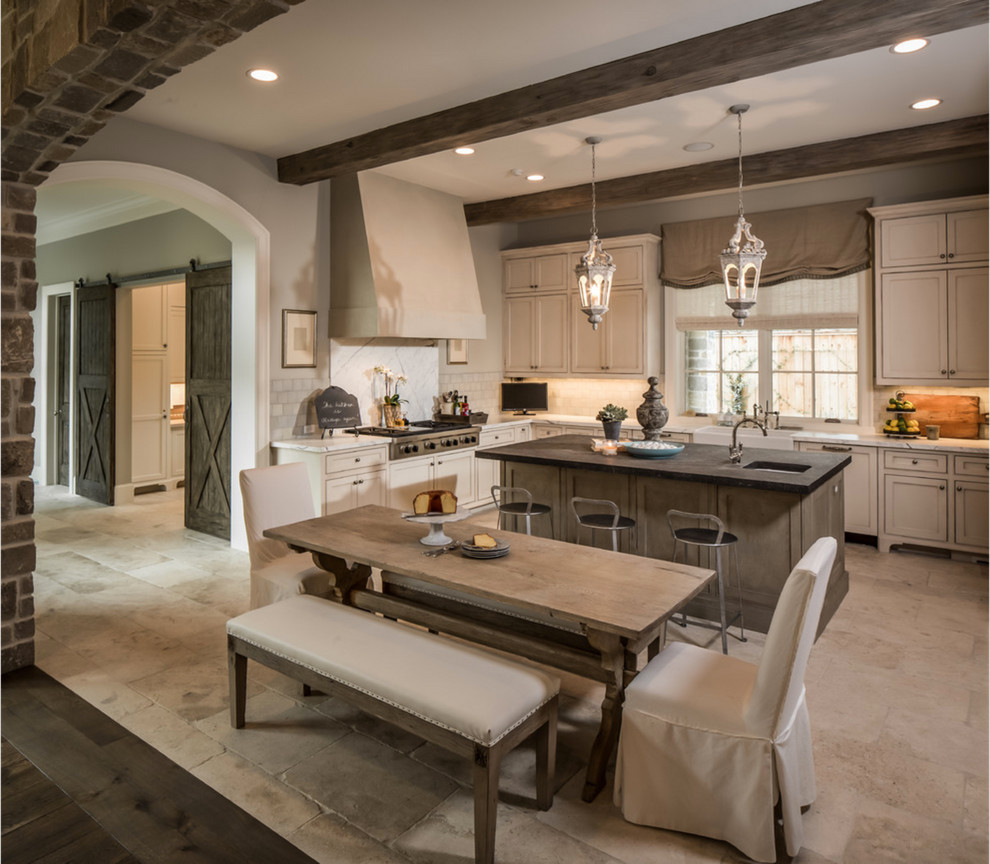 Photo of a large country l-shaped eat-in kitchen in Orange County with a farmhouse sink, recessed-panel cabinets, beige cabinets, granite benchtops, white splashback, ceramic splashback, stainless steel appliances, marble floors, with island and brown floor.