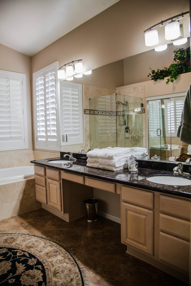 Example of a large transitional master ceramic tile drop-in bathtub design in Phoenix with raised-panel cabinets, light wood cabinets, beige walls, an undermount sink and granite countertops
