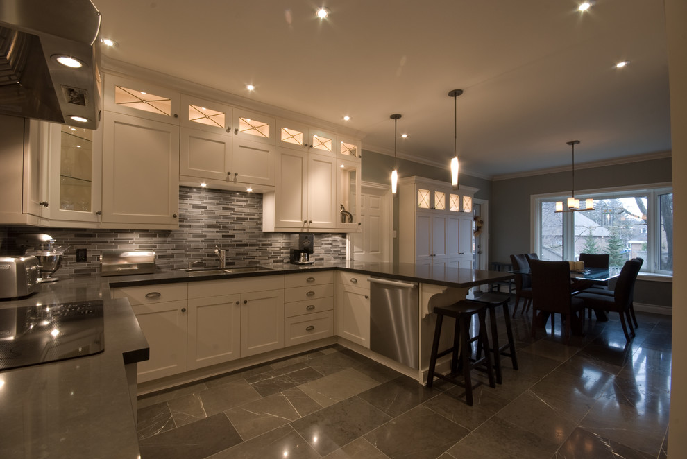 Example of a transitional u-shaped marble floor eat-in kitchen design in Toronto with an undermount sink, recessed-panel cabinets, white cabinets, quartz countertops, multicolored backsplash, glass tile backsplash, stainless steel appliances and a peninsula