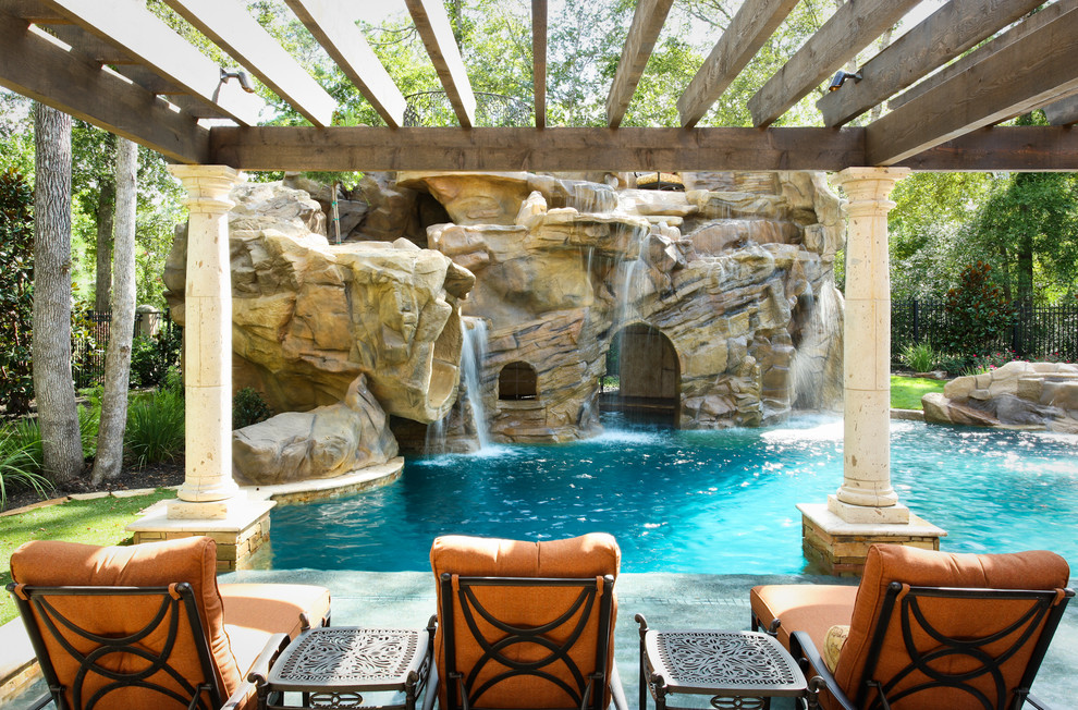 Photo of a mediterranean backyard custom-shaped natural pool in Houston with a water slide.