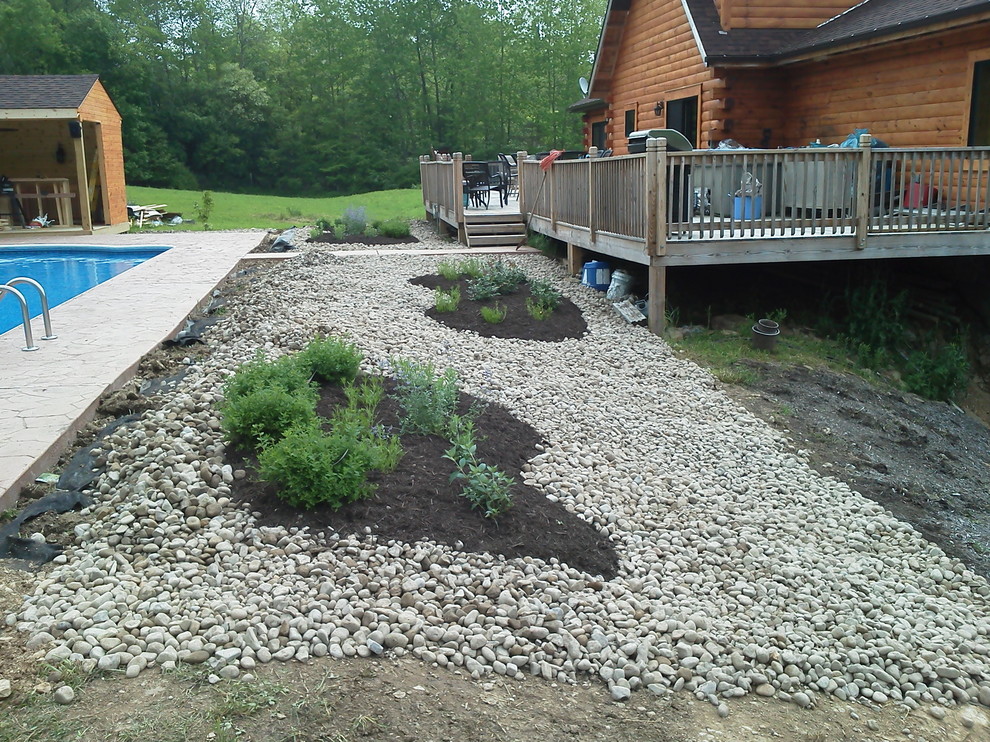 Backyard brick and custom-shaped pool photo