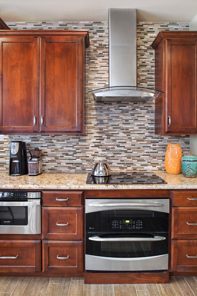 Inspiration for a large transitional galley porcelain tile eat-in kitchen remodel in Austin with an undermount sink, recessed-panel cabinets, medium tone wood cabinets, granite countertops, mosaic tile backsplash, stainless steel appliances, beige walls, a peninsula and multicolored backsplash