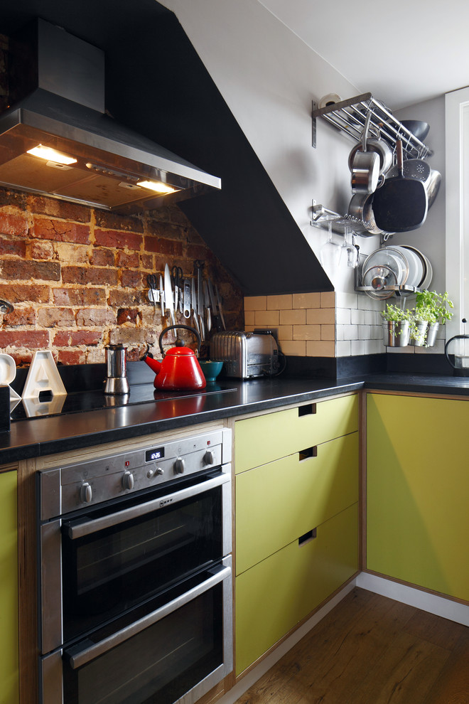 Small modern u-shaped separate kitchen in Sussex with flat-panel cabinets, green cabinets, solid surface benchtops, white splashback, subway tile splashback, stainless steel appliances, no island and laminate floors.