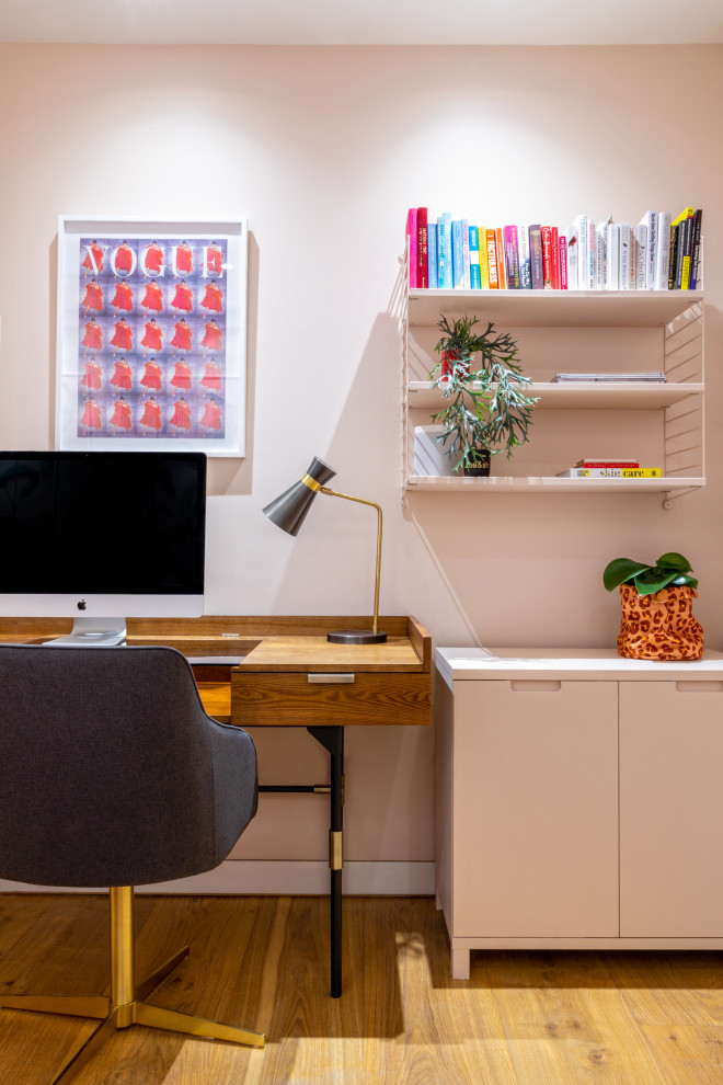 На фото: рабочее место среднего размера в современном стиле с розовыми стенами, светлым паркетным полом, отдельно стоящим рабочим столом и обоями на стенах