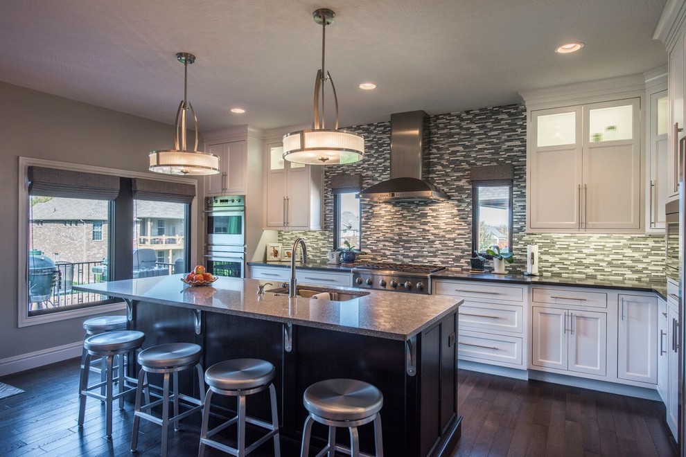 Open concept kitchen - large transitional l-shaped dark wood floor open concept kitchen idea with a double-bowl sink, beaded inset cabinets, white cabinets, granite countertops, multicolored backsplash, matchstick tile backsplash, stainless steel appliances and an island
