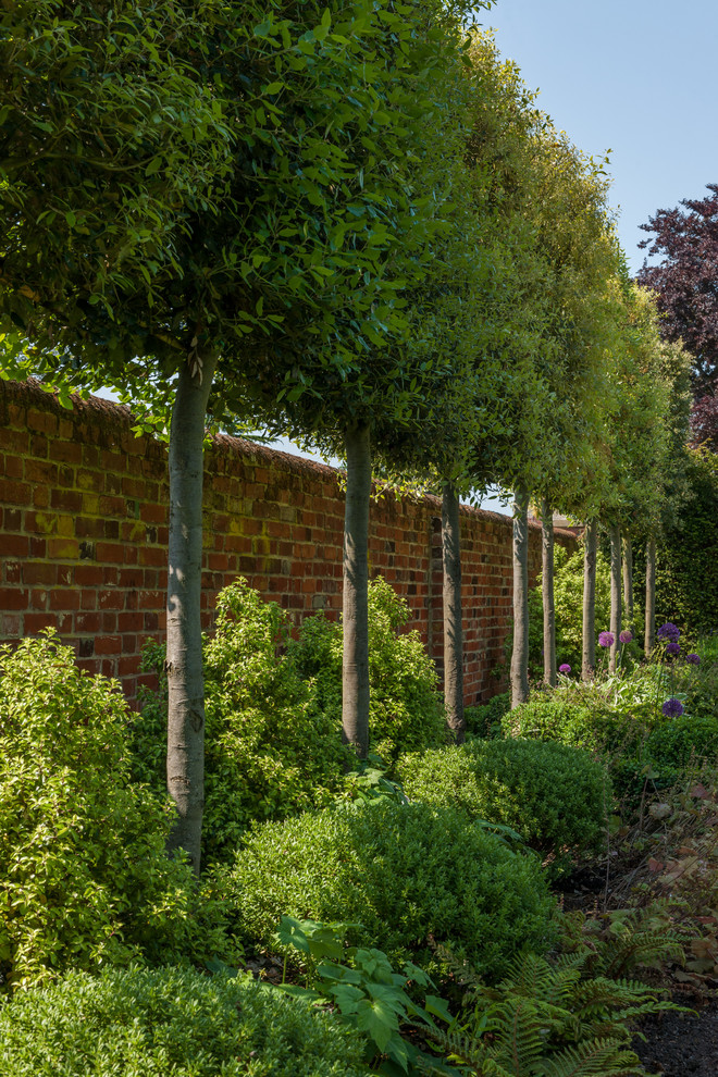 This is an example of a mid-sized traditional backyard formal garden in Hertfordshire.