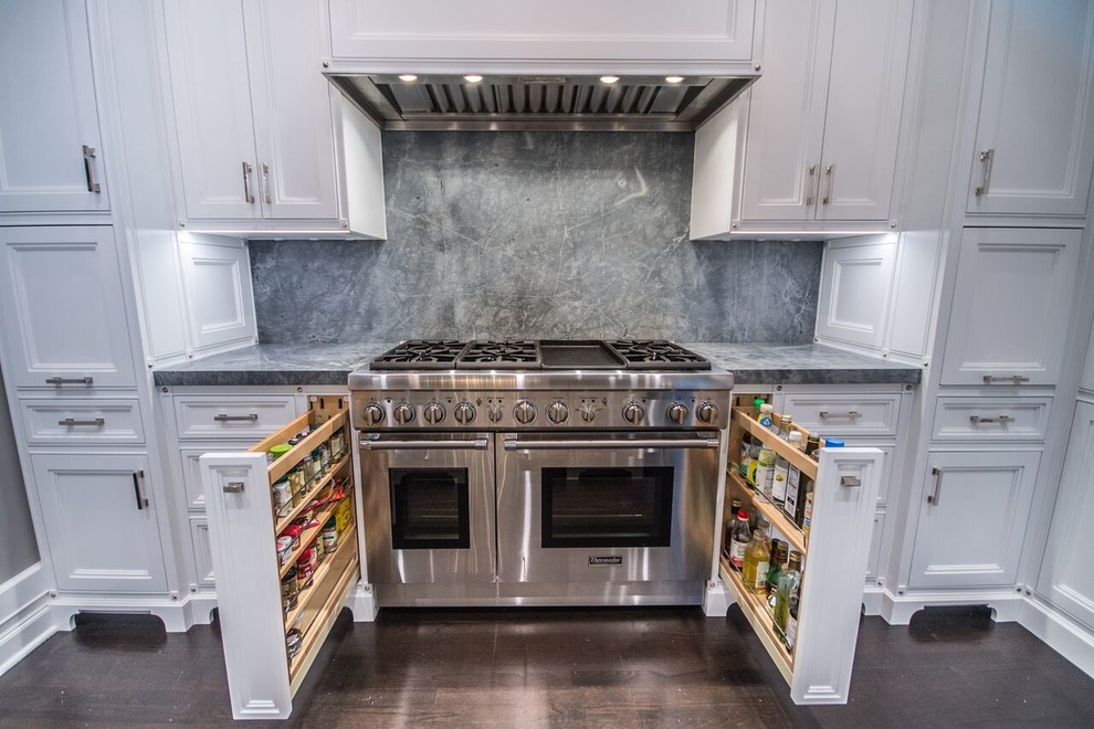 Mid-sized transitional u-shaped dark wood floor eat-in kitchen photo in Chicago with a farmhouse sink, recessed-panel cabinets, white cabinets, quartzite countertops, stone slab backsplash, stainless steel appliances, a peninsula and gray backsplash