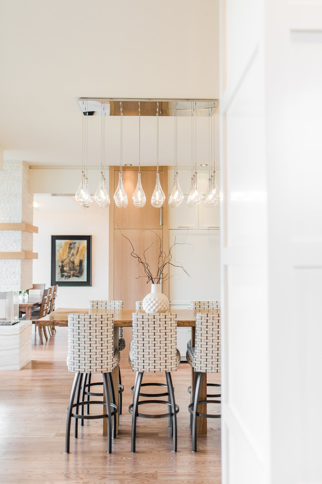 Inspiration for an expansive contemporary eat-in kitchen in Calgary with shaker cabinets, white cabinets, quartzite benchtops, panelled appliances, light hardwood floors and with island.