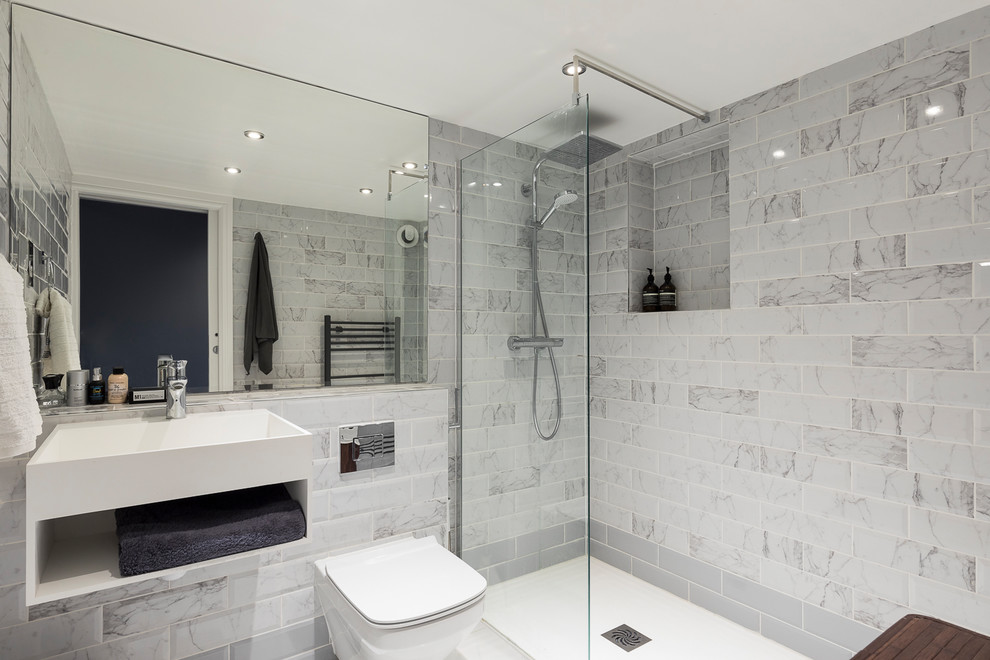 Large asian kids bathroom in London with flat-panel cabinets, white cabinets, a japanese tub, an open shower, a wall-mount toilet, multi-coloured tile, ceramic tile, multi-coloured walls, mosaic tile floors, a drop-in sink, limestone benchtops, multi-coloured floor and an open shower.