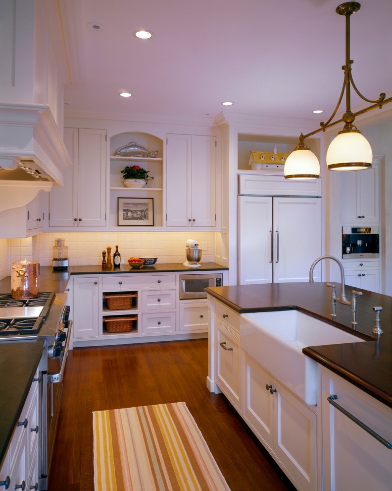 Design ideas for a large country u-shaped open plan kitchen in Boston with recessed-panel cabinets, white cabinets, granite benchtops, with island, a farmhouse sink, red splashback, ceramic splashback, stainless steel appliances, medium hardwood floors and brown floor.