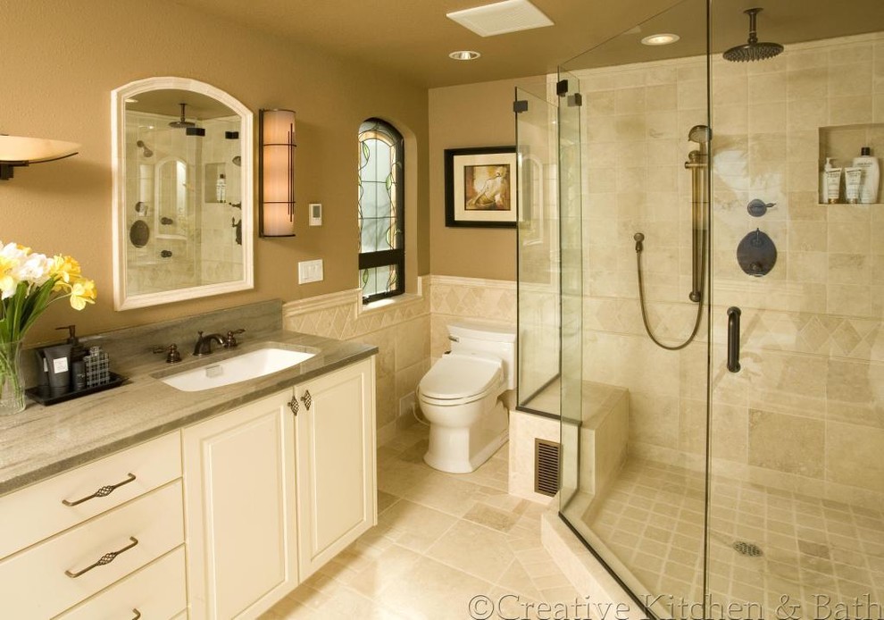Design ideas for a mid-sized mediterranean bathroom in Seattle with raised-panel cabinets, white cabinets, a corner shower, a one-piece toilet, beige tile, ceramic tile, brown walls, ceramic floors, an undermount sink and engineered quartz benchtops.