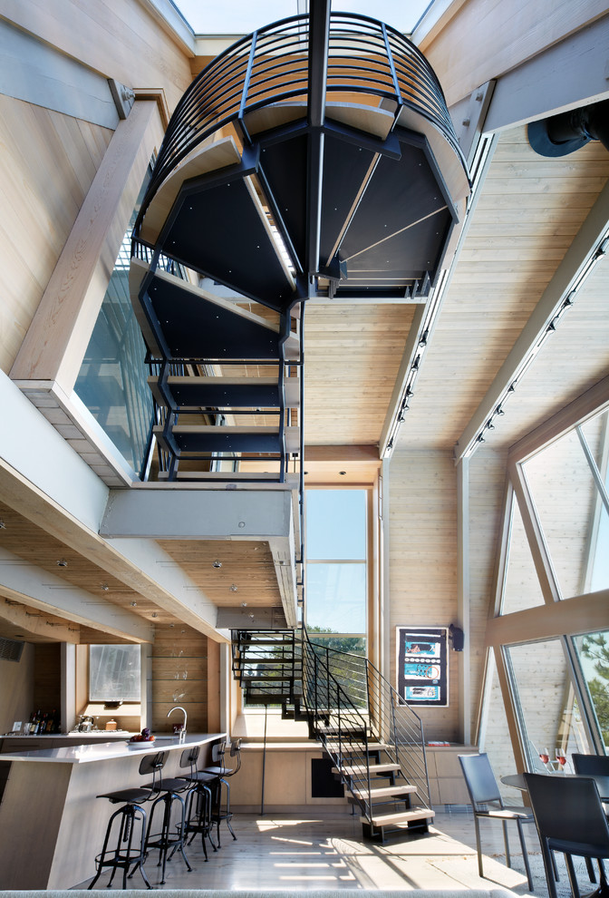 Photo of an expansive contemporary wood u-shaped staircase in New York with open risers and metal railing.