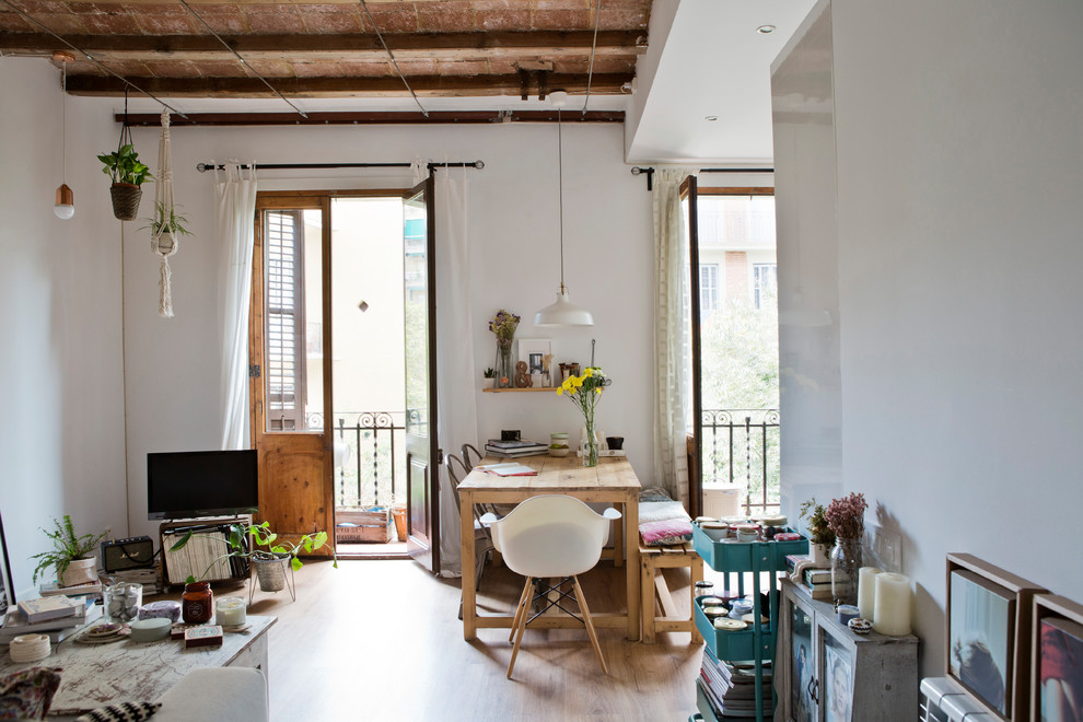 Mid-sized eclectic dining room in Barcelona with white walls, light hardwood floors, no fireplace and beige floor.