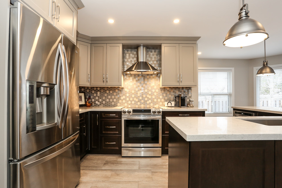 Mid-sized transitional l-shaped porcelain tile enclosed kitchen photo in Toronto with an undermount sink, recessed-panel cabinets, dark wood cabinets, quartz countertops, gray backsplash, mosaic tile backsplash, stainless steel appliances and an island
