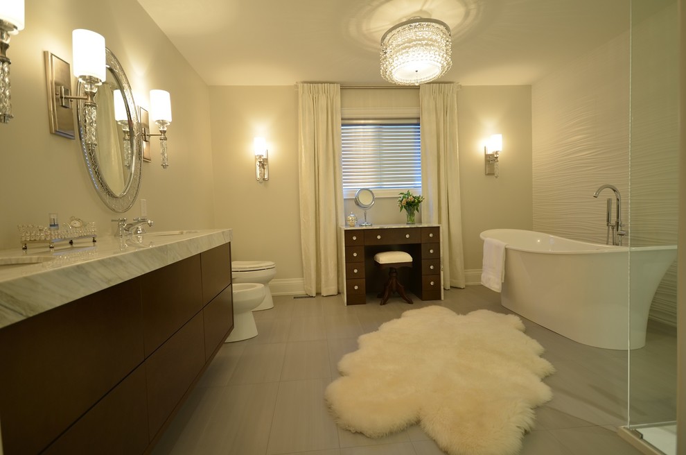 Photo of a large transitional bathroom in Toronto with flat-panel cabinets, dark wood cabinets, marble benchtops, porcelain tile, an undermount sink, a freestanding tub, an alcove shower, a one-piece toilet, gray tile, grey walls and porcelain floors.