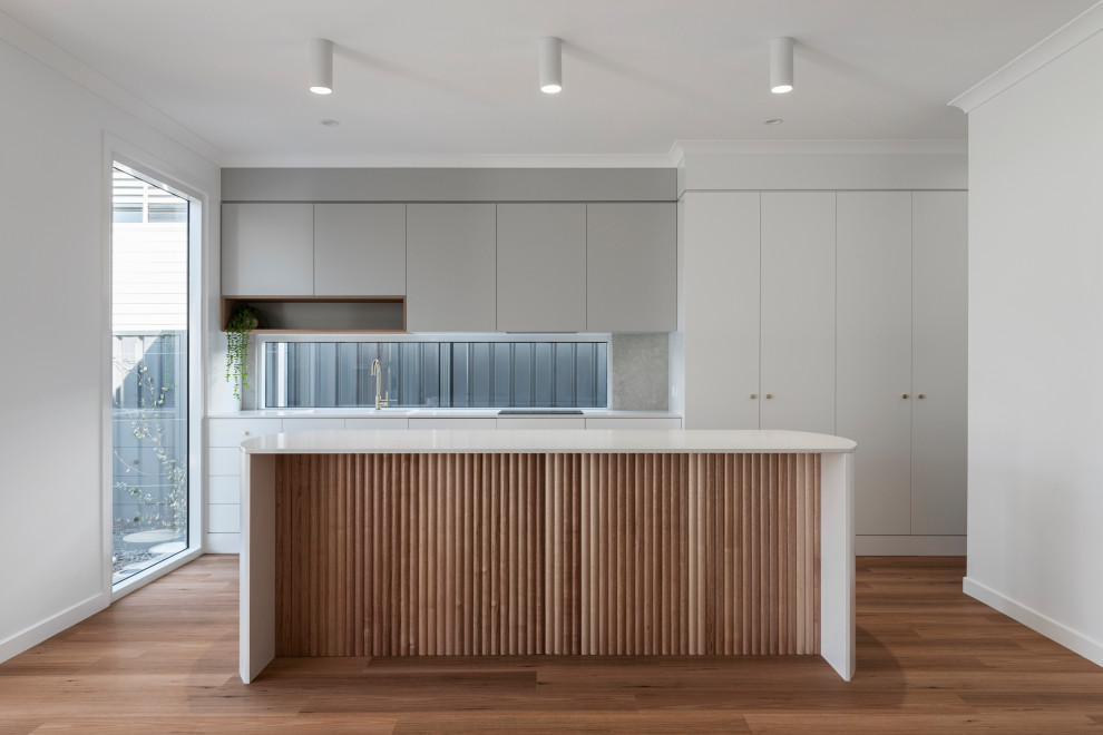 Inspiration for a modern single-wall kitchen in Other with grey cabinets, marble benchtops, window splashback, medium hardwood floors and with island.