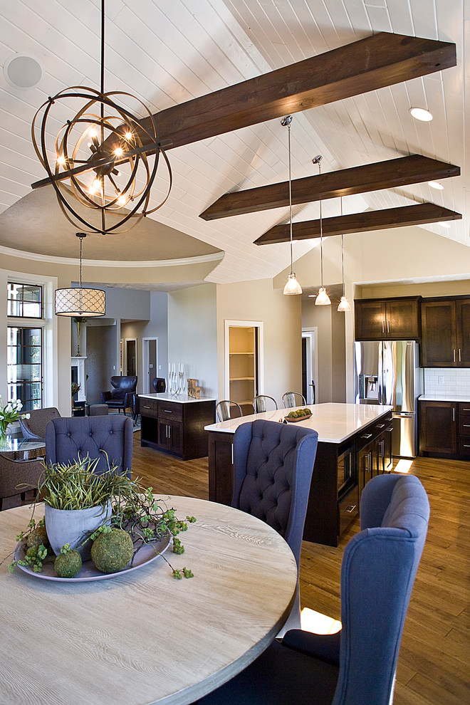 Eat-in kitchen - large transitional l-shaped medium tone wood floor and brown floor eat-in kitchen idea with raised-panel cabinets, dark wood cabinets, quartz countertops, white backsplash, subway tile backsplash, stainless steel appliances and an island