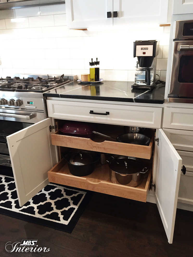 Mid-sized transitional u-shaped dark wood floor and brown floor eat-in kitchen photo with an undermount sink, recessed-panel cabinets, white cabinets, soapstone countertops, white backsplash, subway tile backsplash, stainless steel appliances and an island