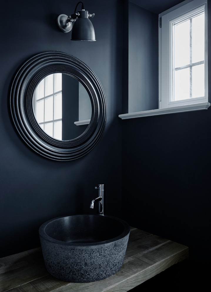 Industrial Gästetoilette mit schwarzer Wandfarbe, Kalkstein, Waschtisch aus Holz und schwarzem Boden in Hamburg
