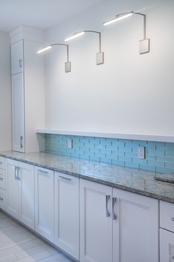 Design ideas for a mid-sized traditional galley dedicated laundry room in Milwaukee with recessed-panel cabinets, white cabinets, quartz benchtops, blue splashback, glass tile splashback, porcelain floors, a side-by-side washer and dryer, beige floor and brown benchtop.