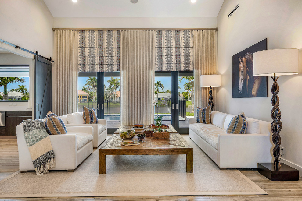 Beach style living room in Miami with grey walls, medium hardwood floors and brown floor.
