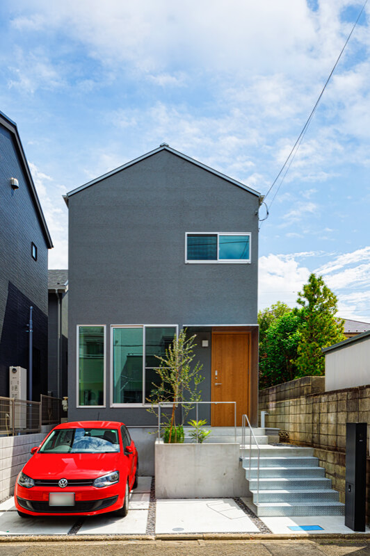 Ejemplo de fachada de casa gris y gris minimalista de tamaño medio de dos plantas con revestimientos combinados, tejado a dos aguas, tejado de metal y escaleras
