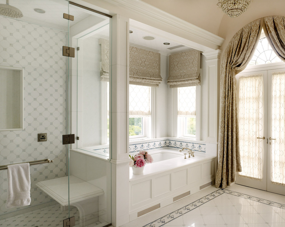 This is an example of a traditional master bathroom in New York with white cabinets, an undermount tub, a corner shower, white tile, beige walls and a hinged shower door.