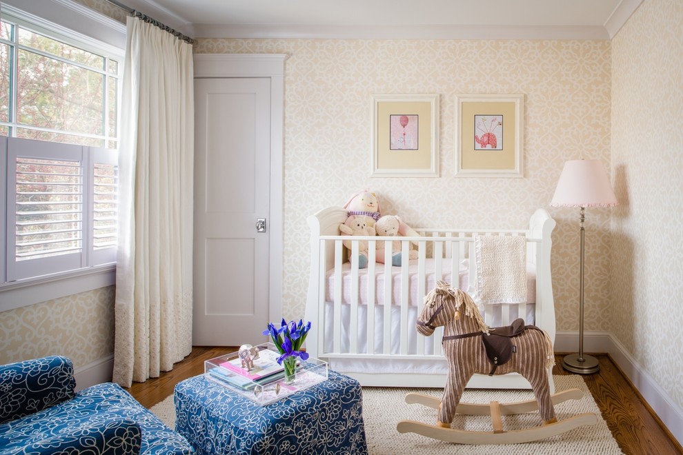Photo of a mid-sized traditional gender-neutral nursery in DC Metro with multi-coloured walls and medium hardwood floors.