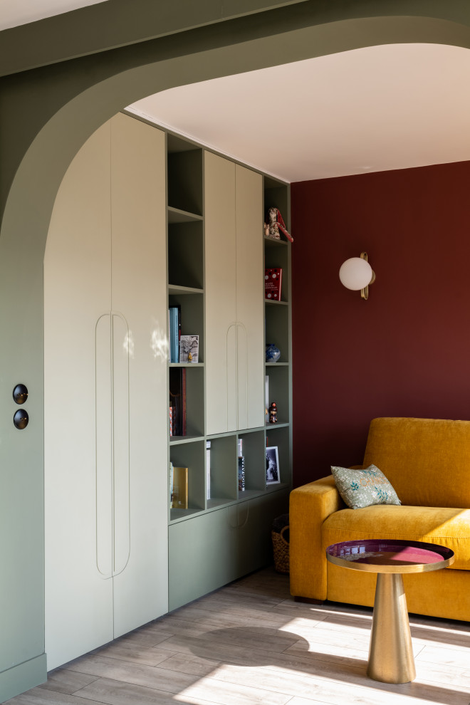 На фото: маленькая открытая гостиная комната в современном стиле с с книжными шкафами и полками, зелеными стенами, светлым паркетным полом, коричневым полом и обоями на стенах без камина, телевизора для на участке и в саду