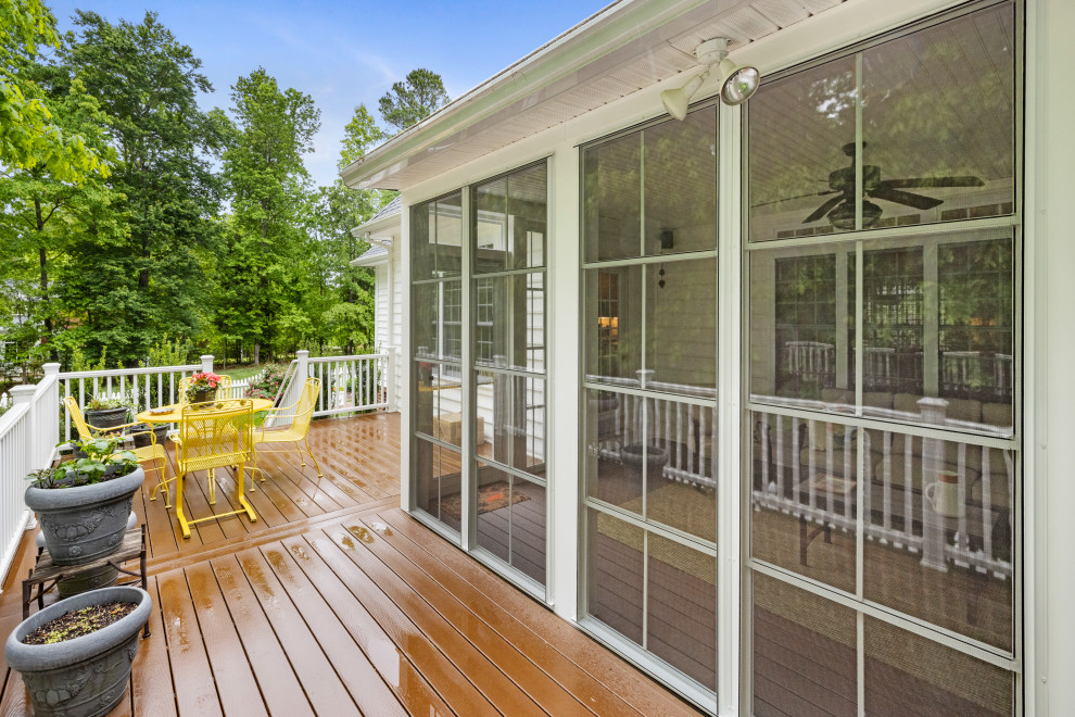 Large classic screened-in back porch idea in Richmond with decking and a roof extension