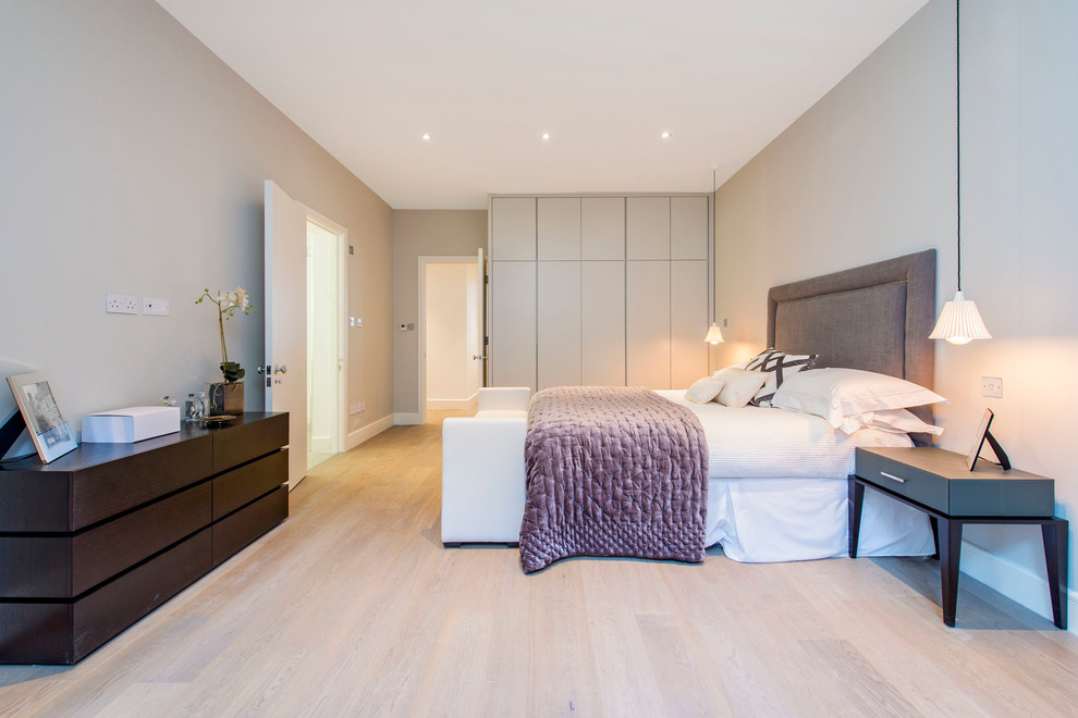 Inspiration for a transitional master bedroom in London with beige walls, light hardwood floors and beige floor.