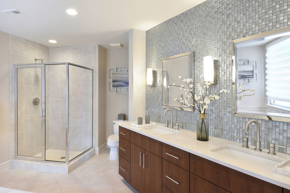Design ideas for a large modern master bathroom in Atlanta with flat-panel cabinets, medium wood cabinets, a corner shower, a two-piece toilet, gray tile, mosaic tile, grey walls, ceramic floors, an undermount sink and limestone benchtops.