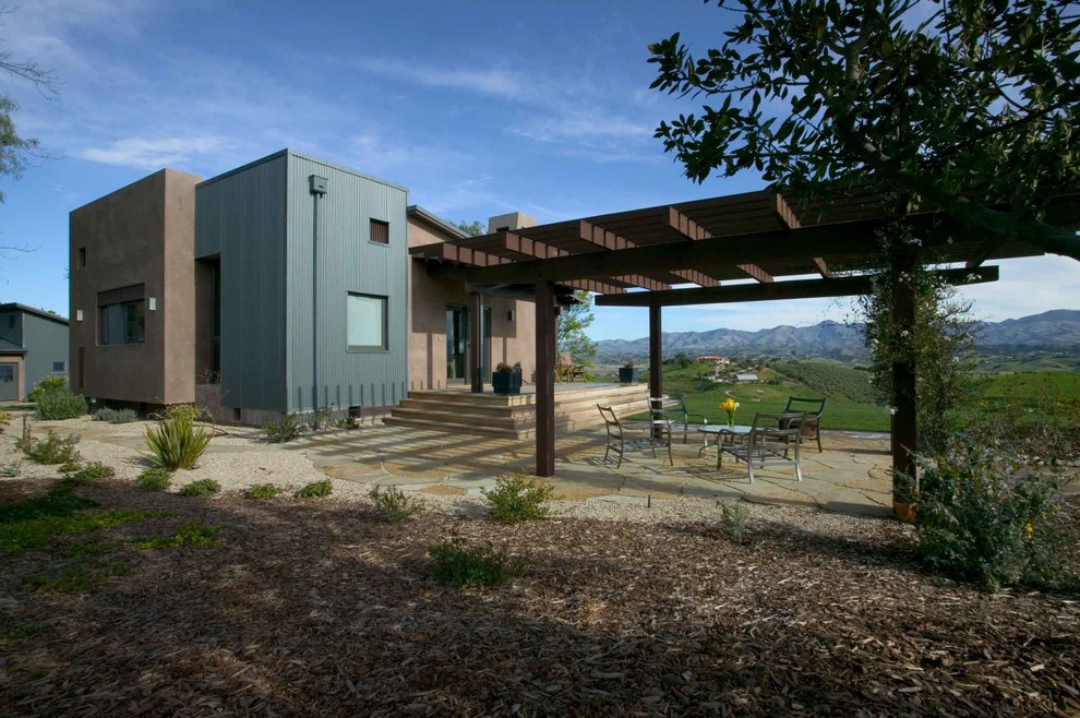 This is an example of a small contemporary one-storey grey exterior in Santa Barbara with mixed siding and a flat roof.