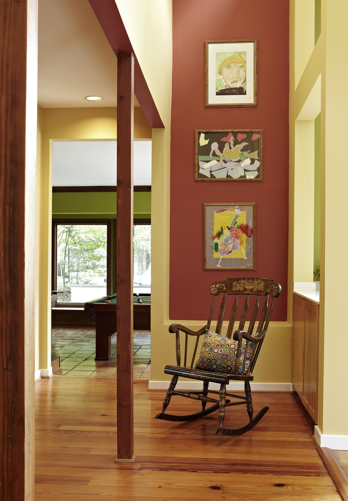 This is an example of a mid-sized eclectic hallway in DC Metro with red walls and medium hardwood floors.