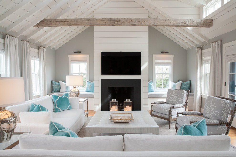 Large beach style open concept living room in Boston with grey walls, a standard fireplace, a wall-mounted tv and light hardwood floors.