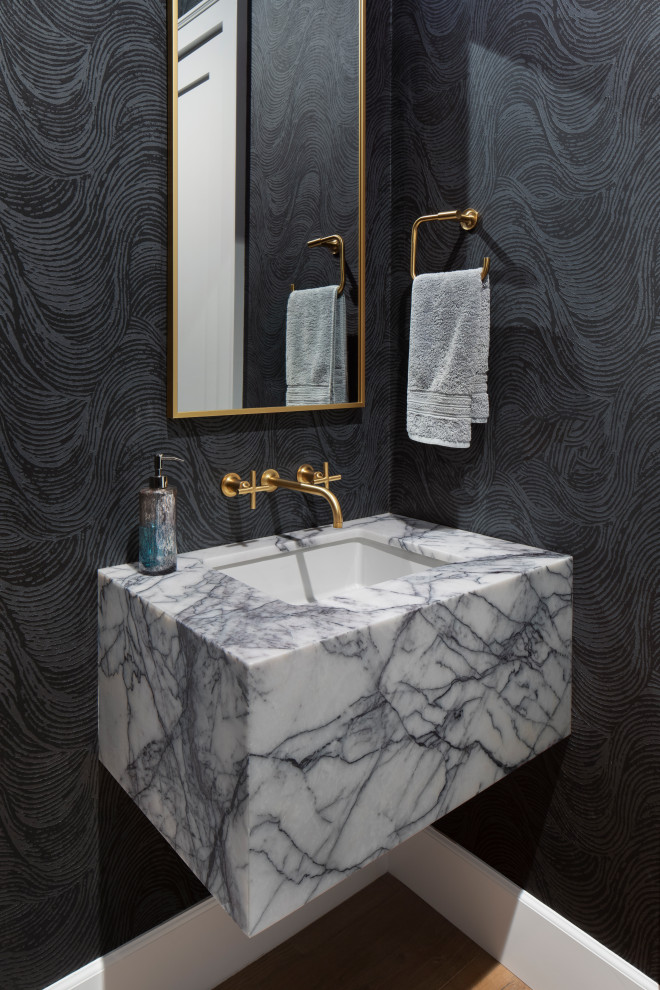 Inspiration for a transitional powder room in San Francisco with black walls, medium hardwood floors, an undermount sink, brown floor, grey benchtops and wallpaper.